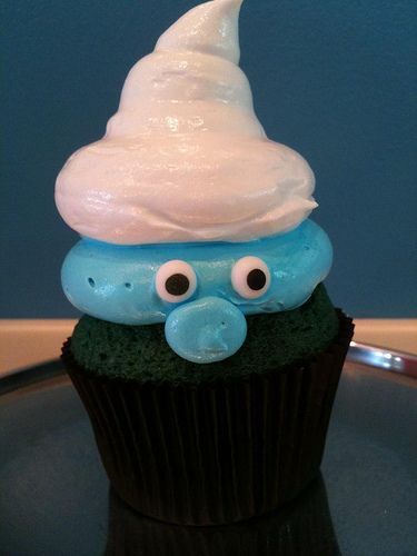 a cupcake with frosting and googly eyes sitting on top of a plate