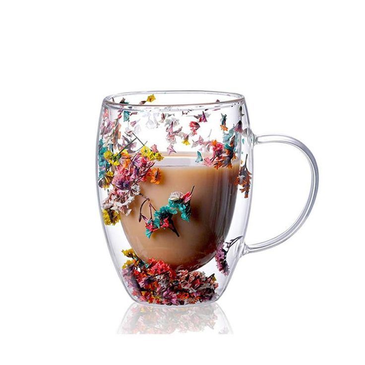 a glass cup filled with liquid and flowers