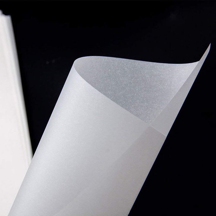 an open book on a black background with white paper in the foreground and a close up view of it's cover