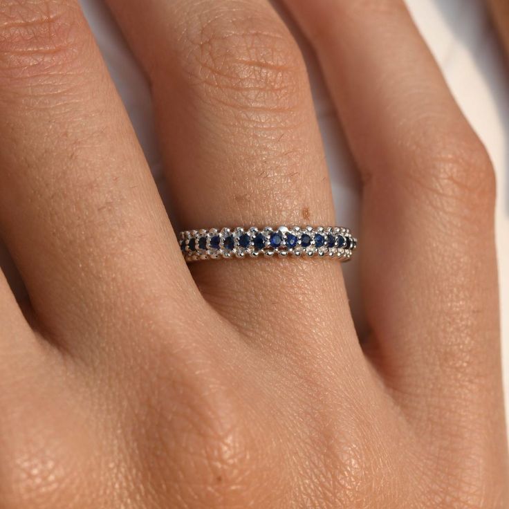 Material: 14k/18k Gold Color Options: Yellow Gold, White Gold, Rose Gold, Platinum ★ StoneBlue Sapphire RoundSize: 1.6 mm * 17Approx Weight (Ct): 0.27★ Band Width: 3.2 mm Sapphire Eternity Band Fine Jewelry, Sapphire Rings With Diamond Cut, Classic Stackable Round Sapphire Ring, White Gold Eternity Band With Halo Setting, Sapphire Stackable Diamond Ring, Fine Jewelry Eternity Band With Halo Setting, Fine Jewelry Round Halo Eternity Band, 14k White Gold Eternity Band For Promise Ring, Stackable Sapphire Diamond Ring