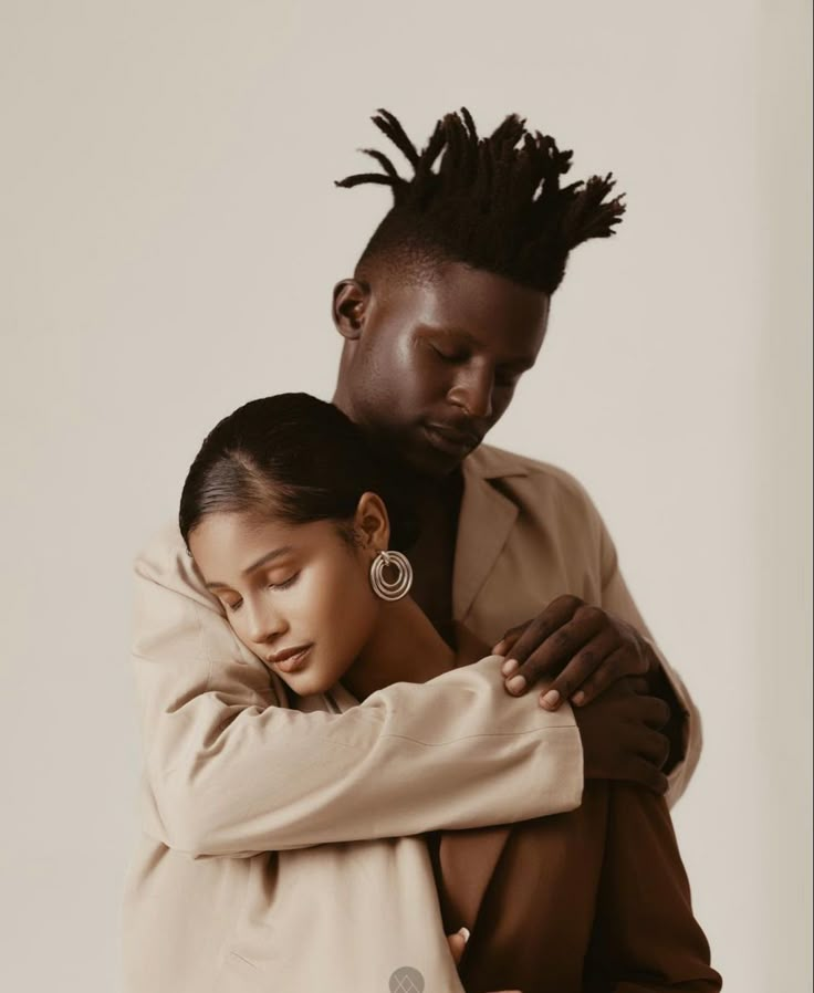 a man and woman embracing each other in front of a white background