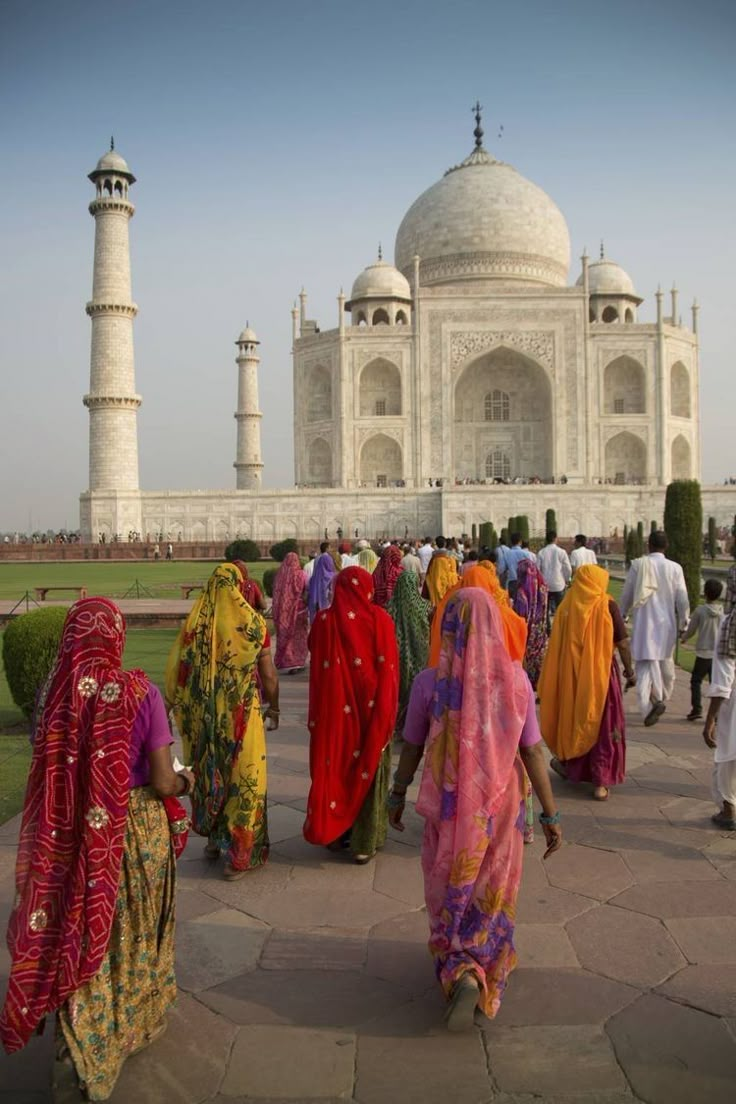 women in colorful sari walking towards the tajwa