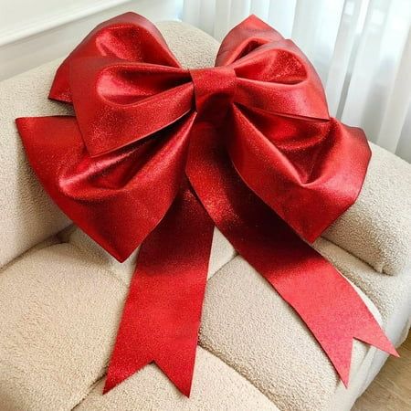 a large red bow sitting on top of a white chair