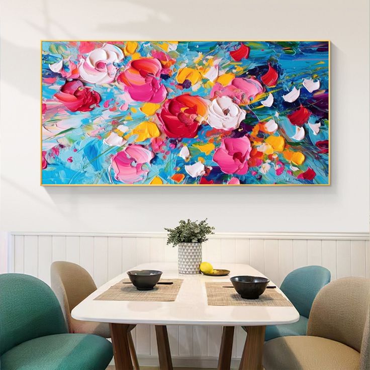 a painting hanging on the wall above a table with two chairs and a vase filled with flowers