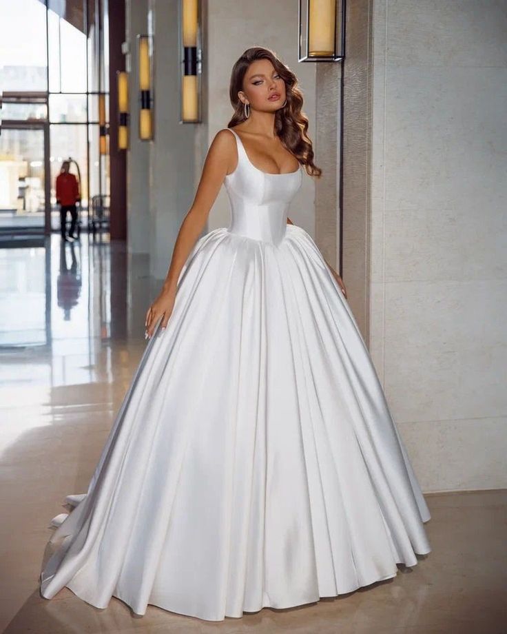 a woman in a white wedding dress posing for the camera