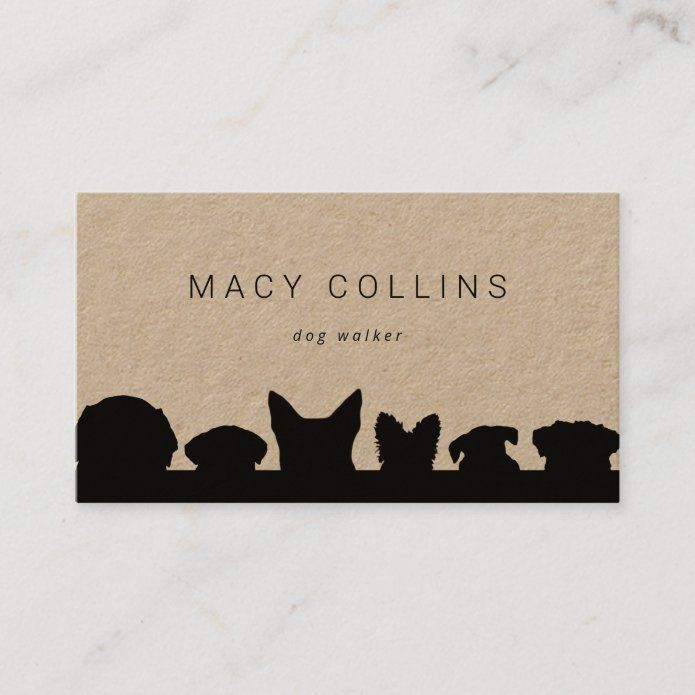 a business card with silhouettes of dogs and cats on it, sitting in front of a marble background