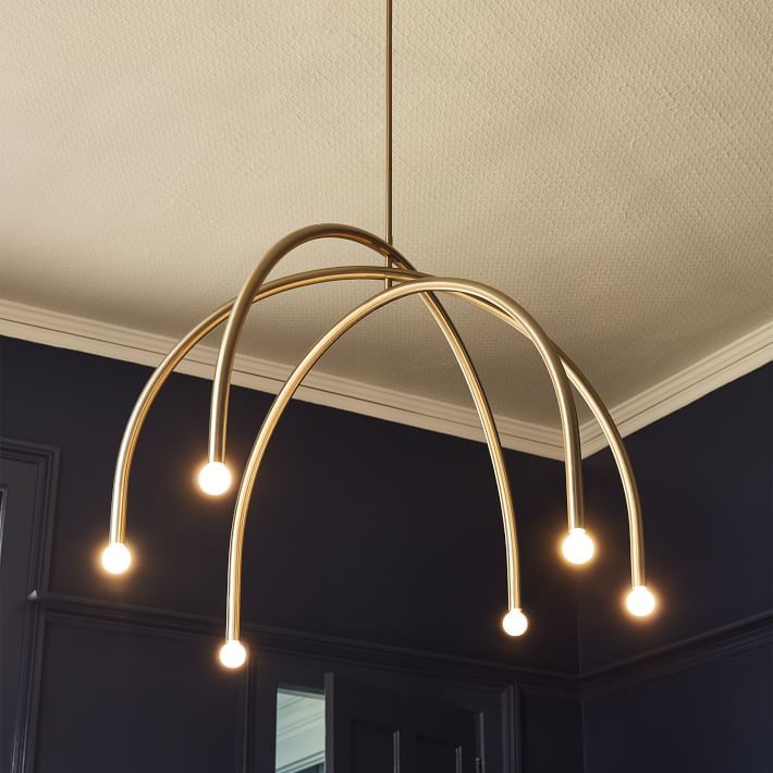 a chandelier hanging from the ceiling in a room with black walls and white trim