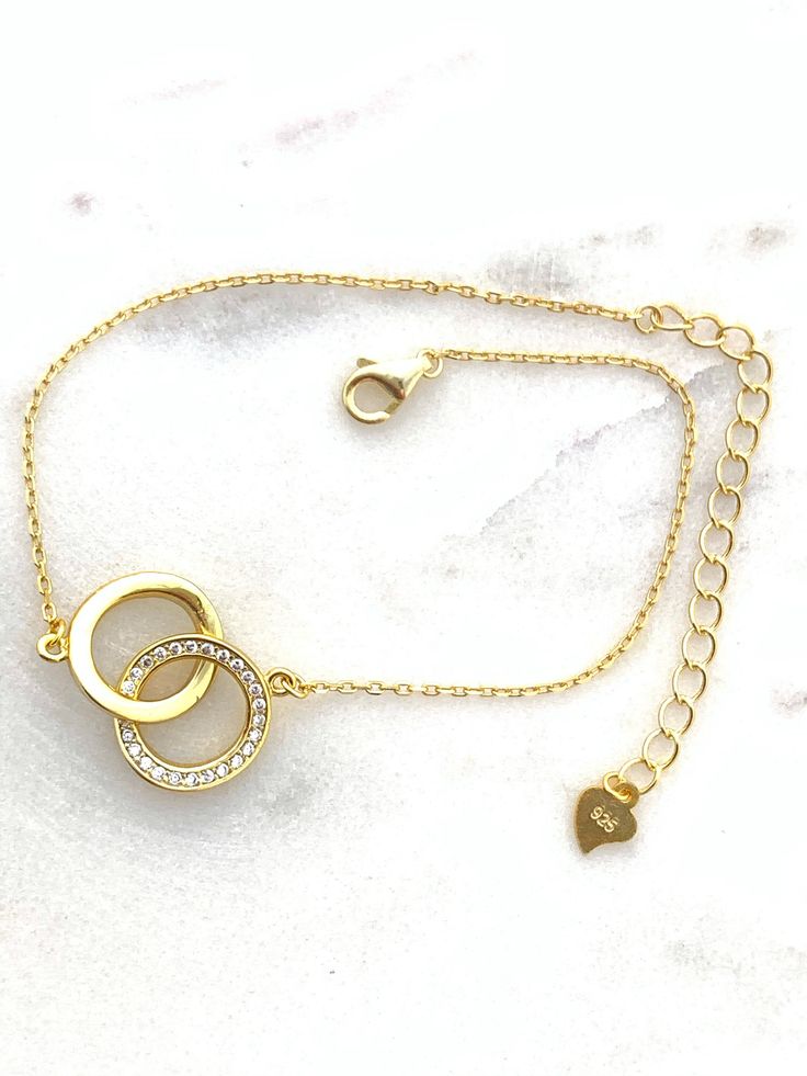 "✦DESCRIPTION ✦ Symbolizing the eternal bond of love, this 14kt yellow gold plated Sterling silver bracelet joins two interlocking open circles. Polished finish. Stationed on a cable chain. Spring ring clasp - Chain bracelet measurement is 7\" inch plus the 2\" inch extension. ✦Dear Customers ✦ We strive to provide the best quality with affordable prices. We take such pride in making sure to create unique, beautiful jewelry for all our Sioro Silver customers, and always seek to provide the very Gold Promise Bracelet For Valentine's Day, Elegant Gold Chain Bracelet For Valentine's Day, Elegant Gold Bracelet For Promise, Dainty Gold Promise Jewelry, Gold Infinity Shaped Metal Jewelry, Gold Charm Bracelet With Adjustable Chain For Wedding, Elegant Gold Charm Bracelet For Valentine's Day, Gold Plated Bracelets For Anniversary On Mother's Day, Gold Plated Bracelets For Mother's Day Anniversary