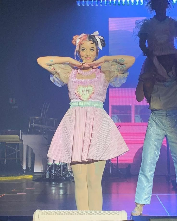 a woman standing on top of a stage with her hands behind her head