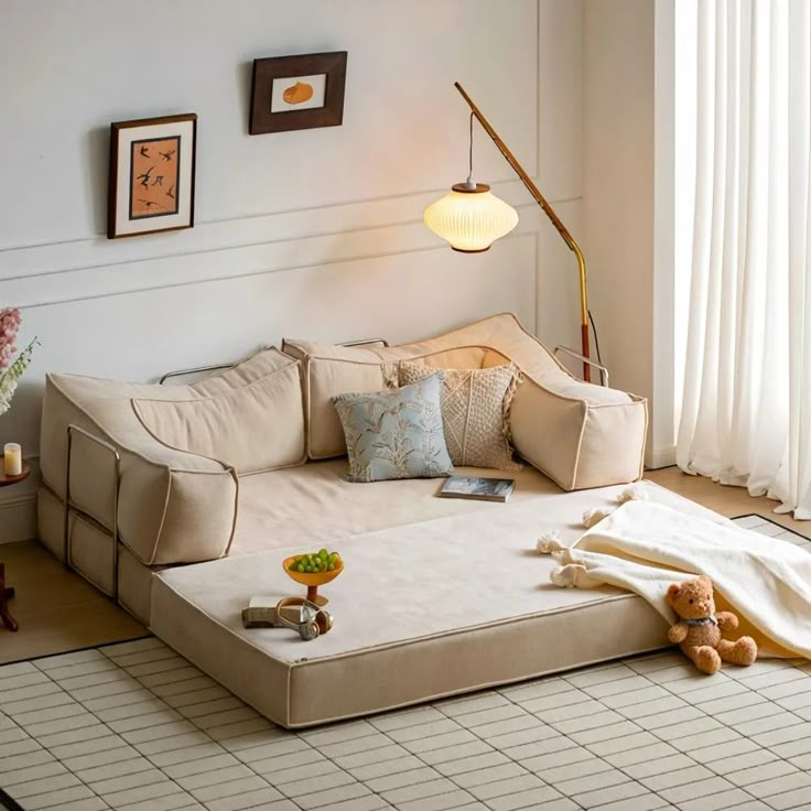 a living room filled with furniture and a teddy bear sitting on the floor next to it