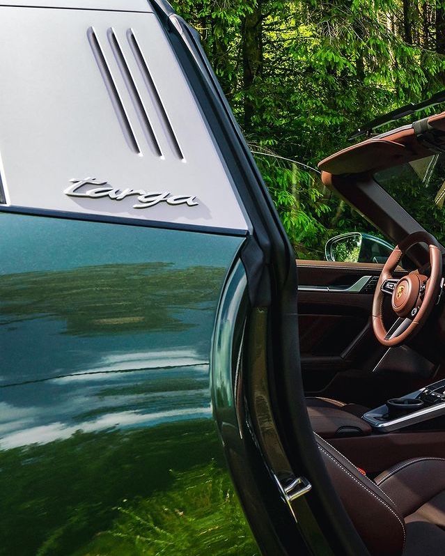 the interior of a green sports car with its door open and driver's seat up