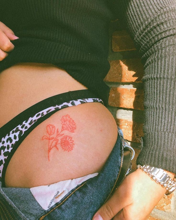 a woman with a flower tattoo on her stomach