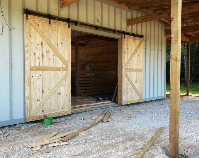 an open barn door on the side of a building with wood planks around it