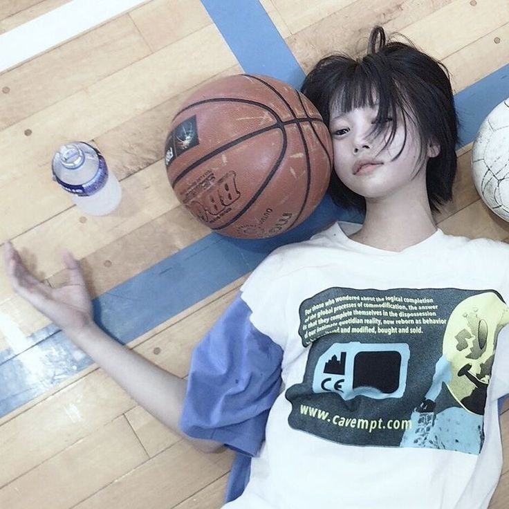 a person laying on the floor with some basketballs