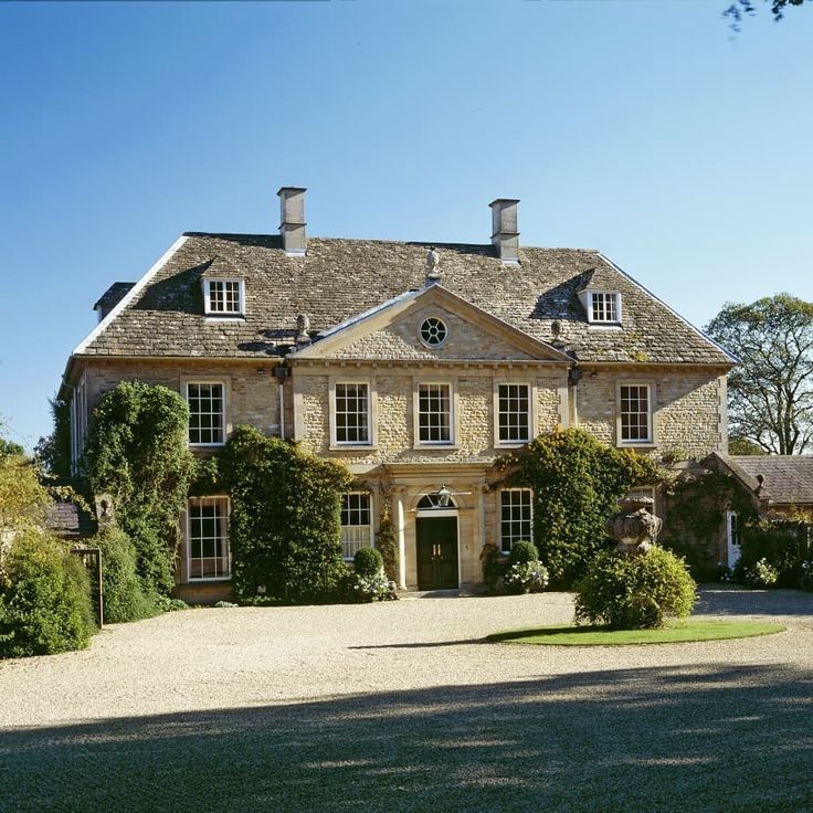 a large house with many windows and lots of greenery