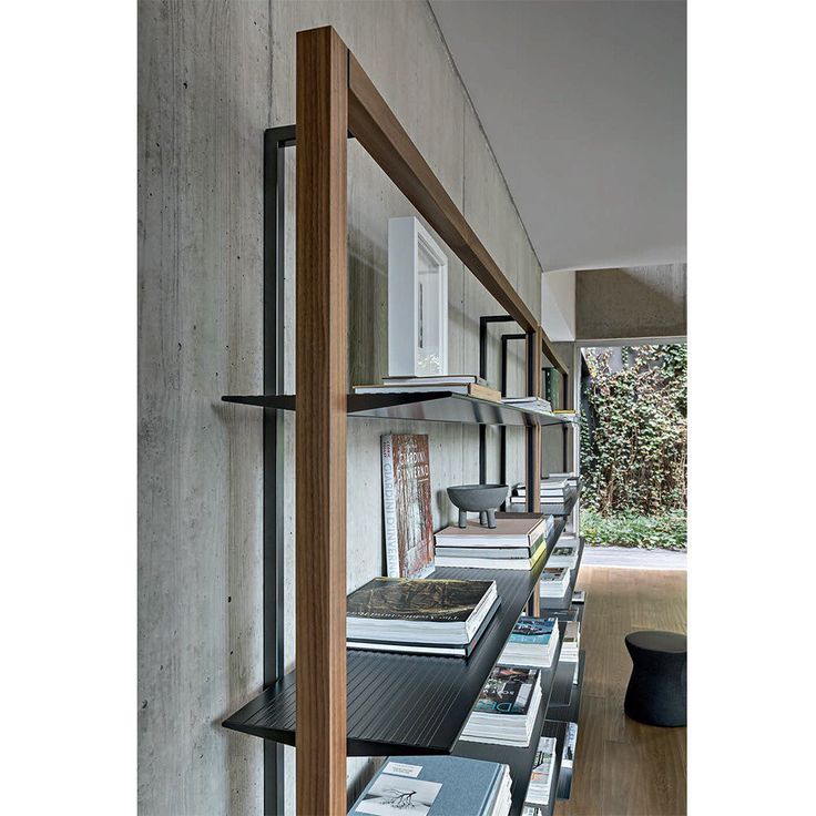 a long row of books sitting on top of a wooden shelf