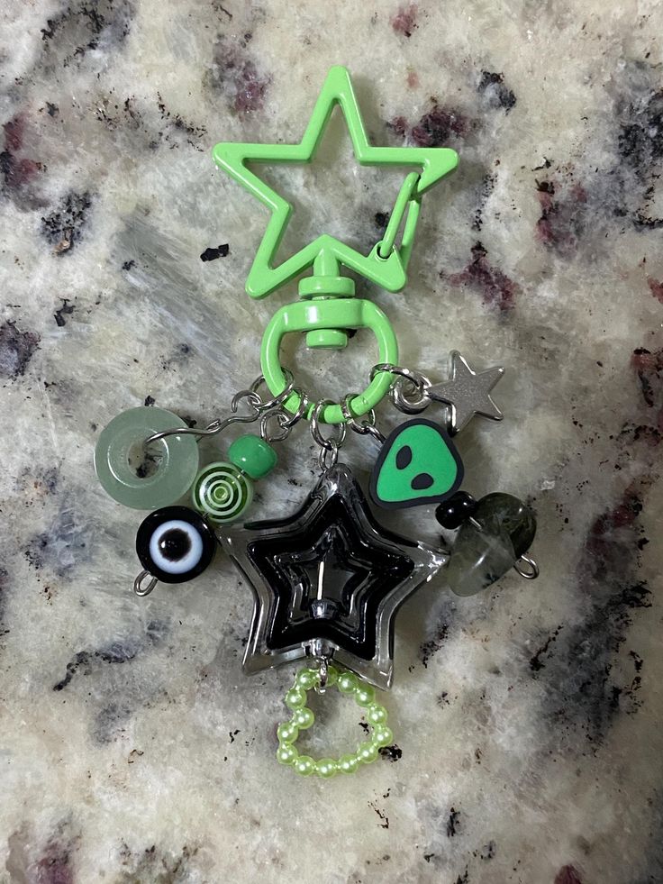 a star shaped keychain with various items attached to it on a marble surface