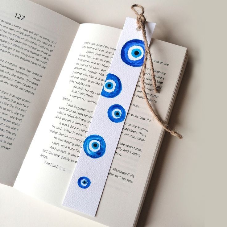 an open book with blue eyes on it and a string attached to the front cover