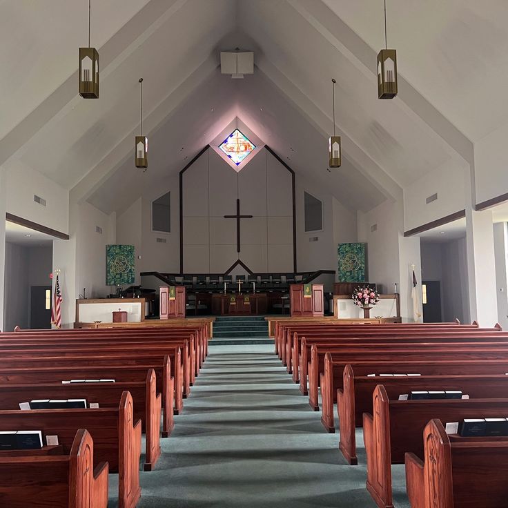 an empty church with pews and stained glass windows