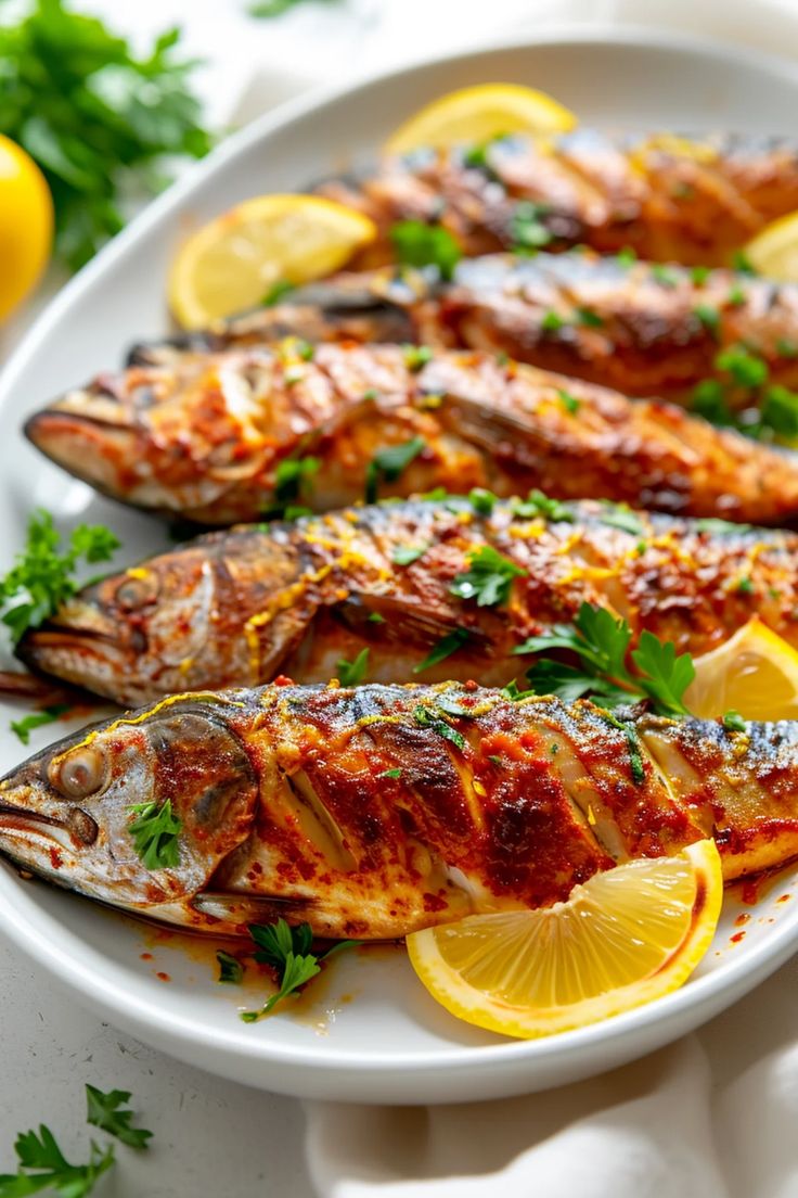 grilled fish on a plate with lemons and parsley