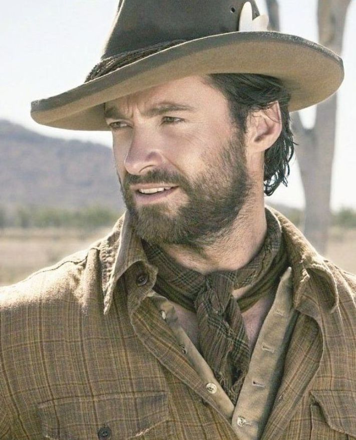 a man wearing a cowboy hat in the desert