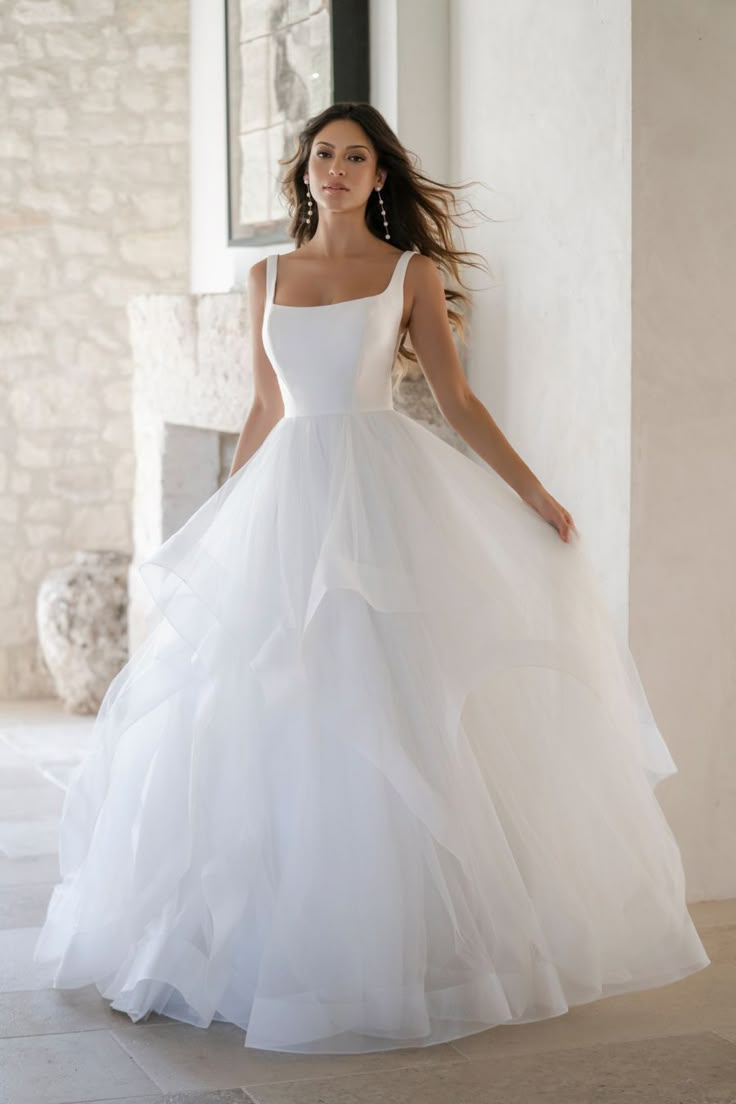 a woman in a white wedding dress posing for the camera