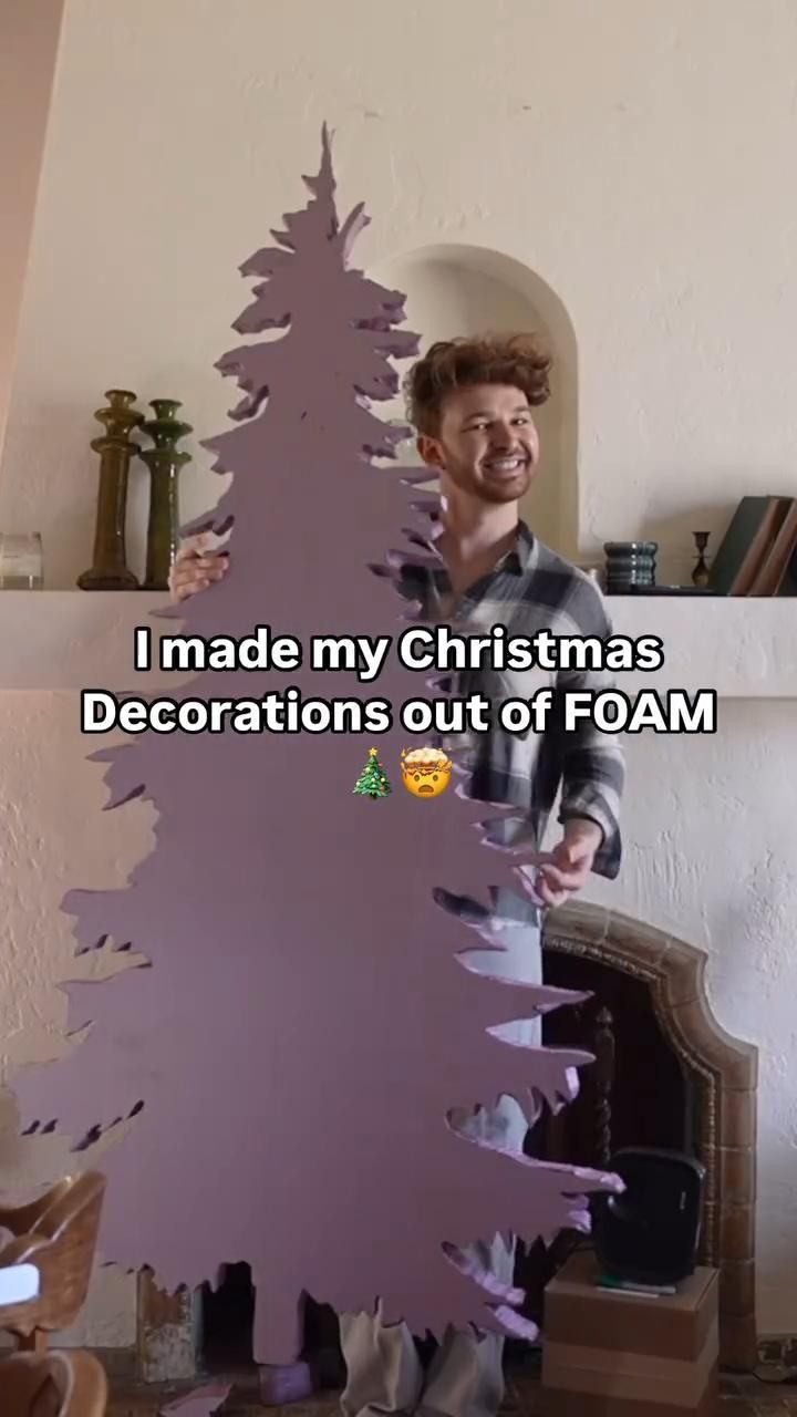 a man standing next to a christmas tree with the words i made my christmas decorations out of foam