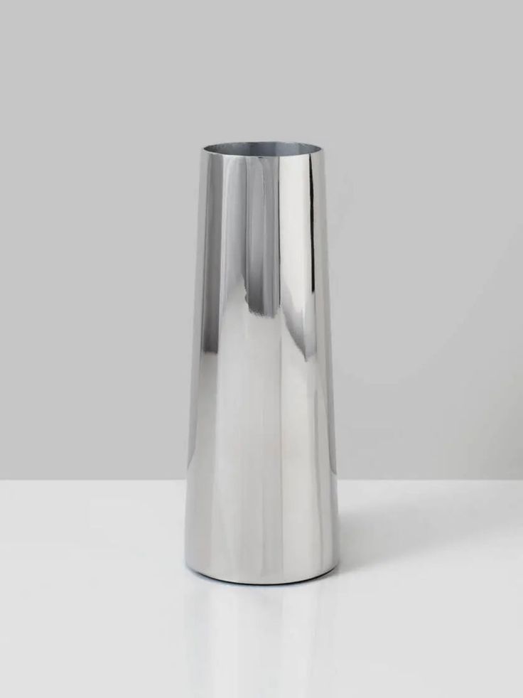 a silver vase sitting on top of a white table