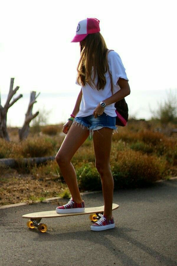 a young woman riding a skateboard down a street