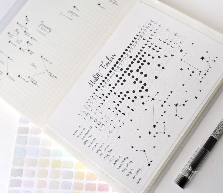 an open notebook with dotted lines and stars on it next to a fountain pen, marker and color swatches