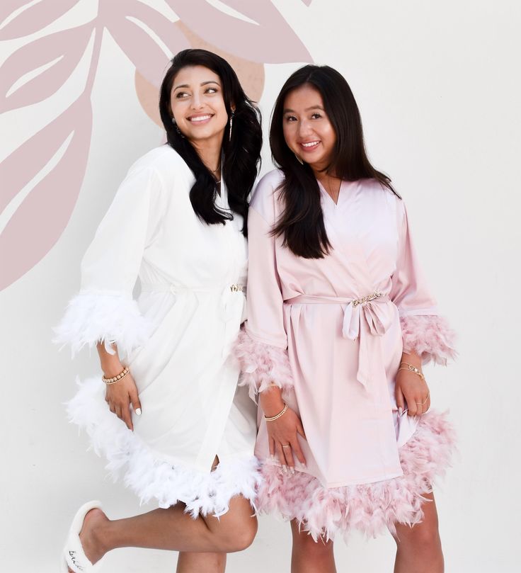 two women dressed in pink and white posing for the camera