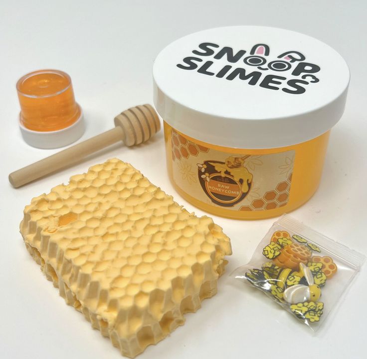 a jar of honey next to some candy and a stick of beeswatche