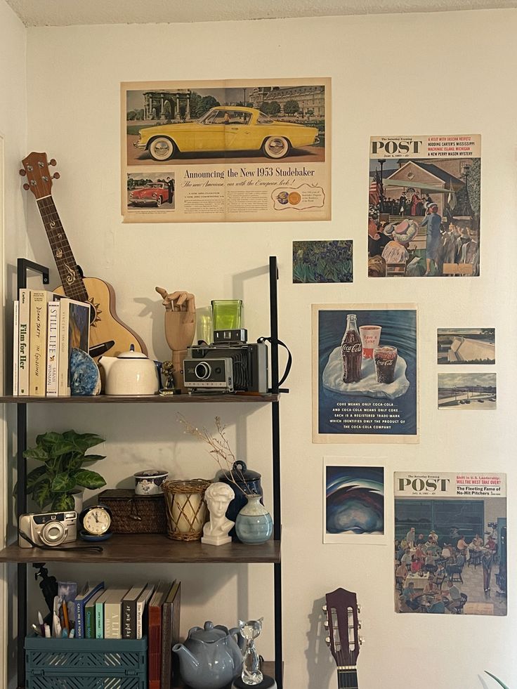 there is a shelf with various items on it in the corner next to a guitar and bookshelf