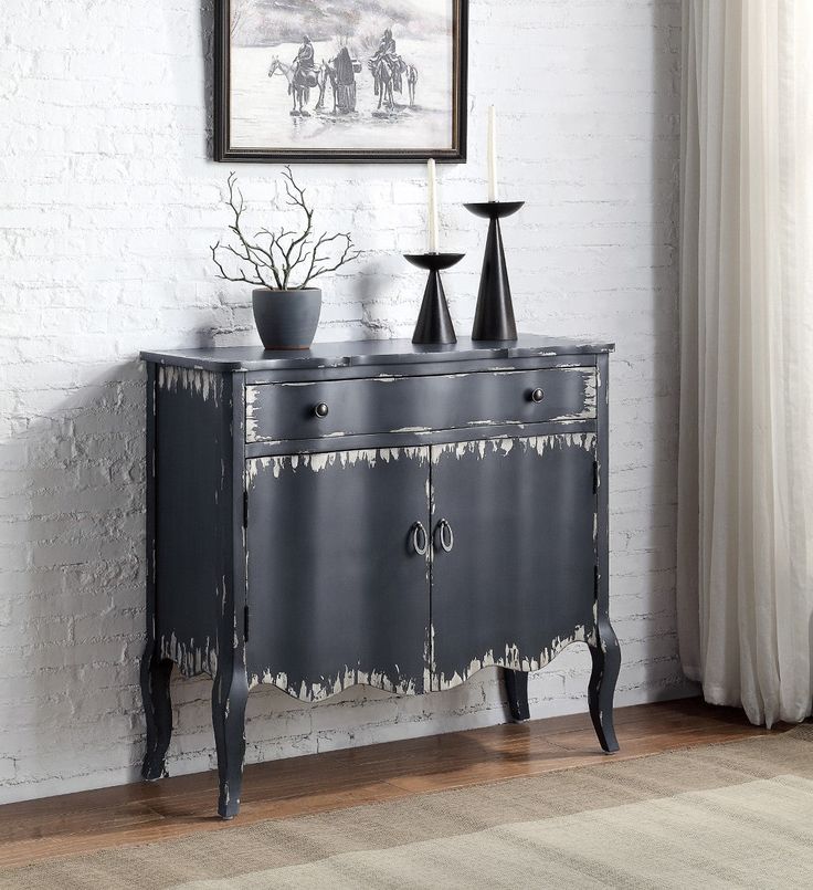 a black cabinet with two vases sitting on top of it