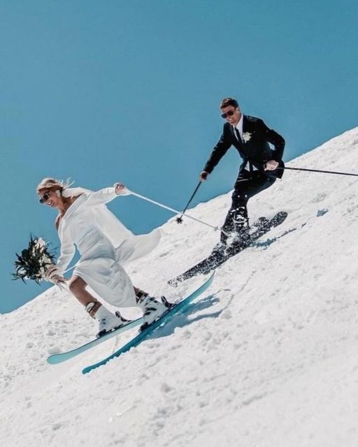 the bride and groom are skiing down the hill