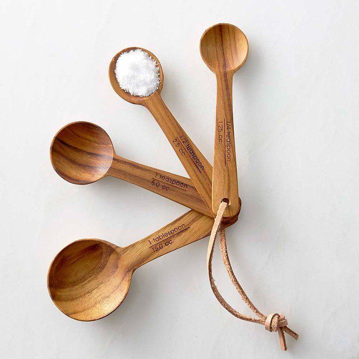 six wooden spoons are tied together on a white surface