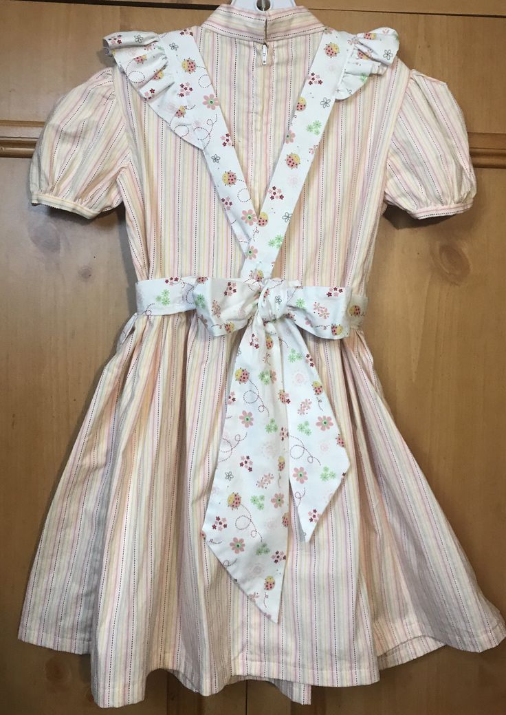 "Dress length (shoulder to bottom hem)27\"/pit to pit 13\"/waist 12 1/2\"/ Apron length (shoulder to bottom hem) 22\"/waist adjustable with sash tie/No pattern supplied/dress is pink green and white striped the apron has a lady bug pattern. The dress is sewn from a 1969 vintage pattern/Please pay attention to measurements size vintage six but please pay attention to measurements/smoke free environment(39)" Cute Cotton A-line Sundress, Cute A-line Cotton Sundress, Cute Fitted A-line Dress, Cute A-line Dress For Casual Wear, Cute A-line Dress For Dress-up Occasions, Cute A-line Sundress For Garden Party, Spring Vintage A-line Cotton Dress, Cute Fitted Vintage Dress With Short Sleeves, Vintage Cotton Dress For Dress-up