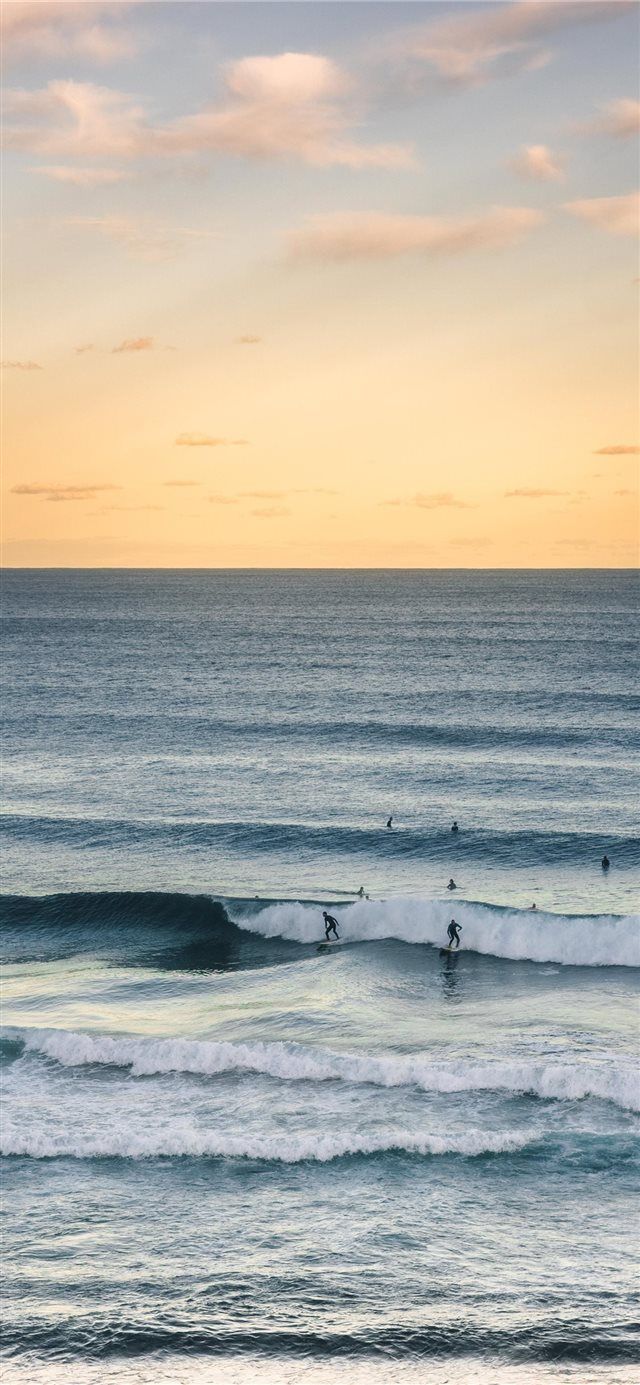 surfers are riding the waves at sunset on their surfboards in the ocean,