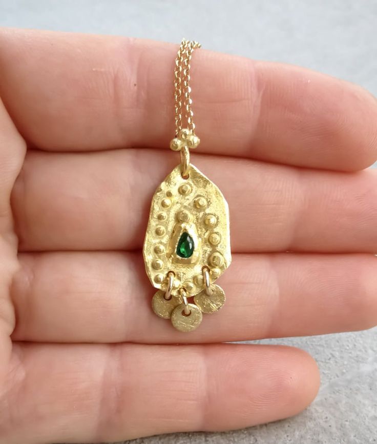 Boho gold necklace 9k 14 k Solid gold necklace with green emerald May birthstone, Yellow gold necklace, Delicate Pendant, Gift for her This solid gold necklace has a rustic textured and is set with a natural green emerald. The pendant has a delicate granulation all around it. This pendant is delicate but has a lot of character, and will upgrade any outfit you'll wear, for everyday use, as for special occasions The pendant can be ordered without the chain too. An excellent choice for anniversary Fine Jewelry Gold Emerald Necklace With Delicate Chain, Gold Emerald Necklace With Delicate Chain, Fine Jewelry, Gold Dainty Emerald Necklace, Dainty Gold Emerald Round Necklace, Gold Plated Emerald Necklace As A Fine Jewelry Gift, Gold Emerald Necklace With Delicate Chain For Gift, Gold Gemstone Necklace For May Birthstone, 17 Jewels Gold Plated Emerald Necklace As Gift, Emerald Necklace With Delicate Yellow Gold Chain