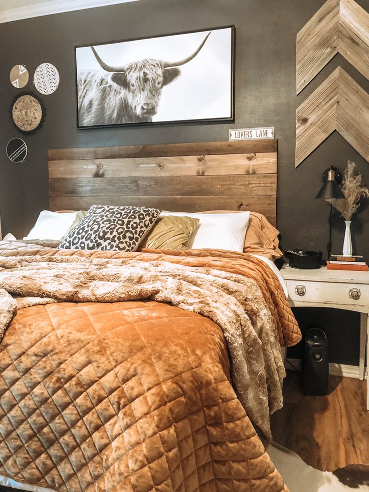 a bedroom with a bed, nightstands and pictures on the wall above it is decorated with wood planks