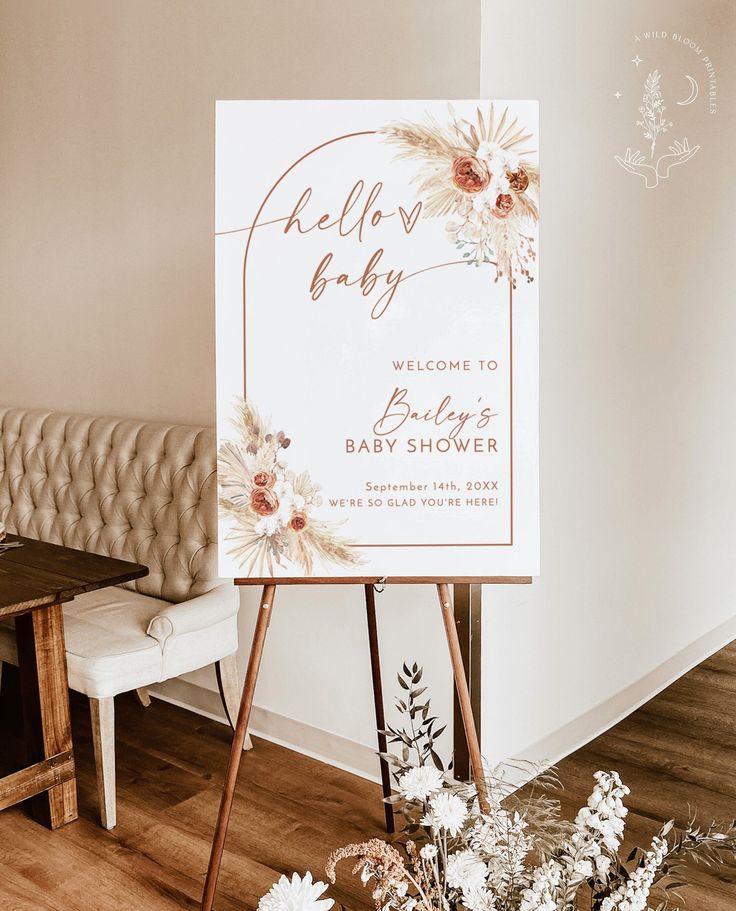 a baby shower sign sitting on top of a wooden easel