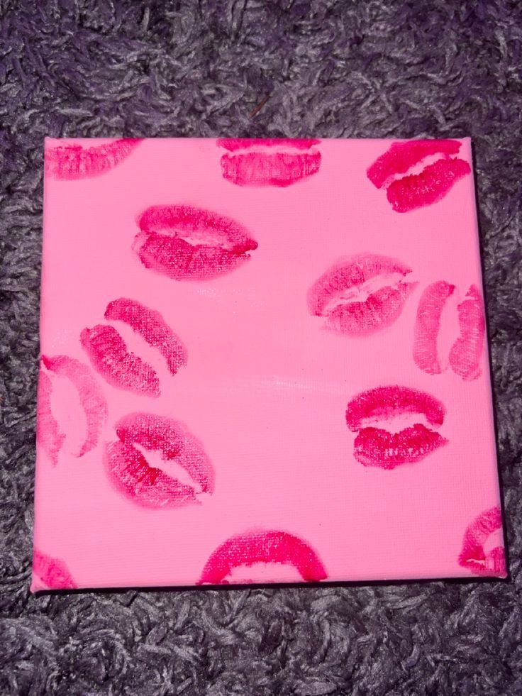 a pink box with lipstick on it sitting on the floor next to a gray carpet