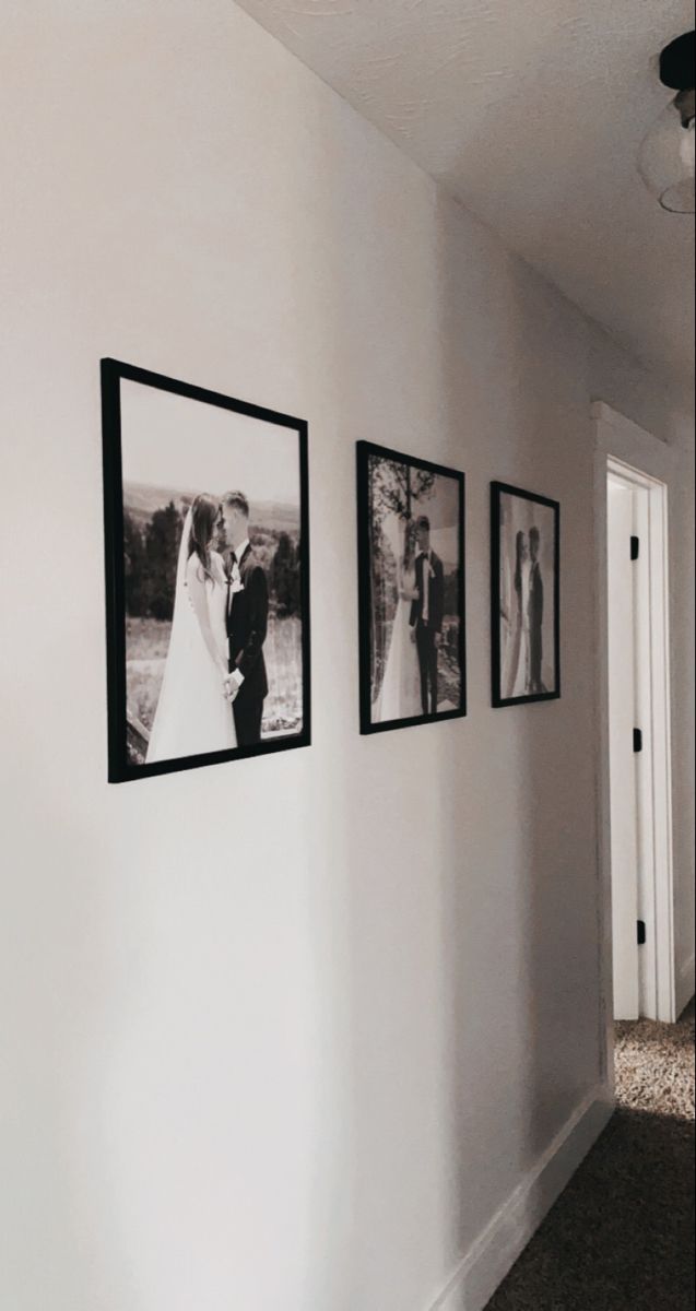 three framed pictures hang on the wall next to a doorway with a bride and groom