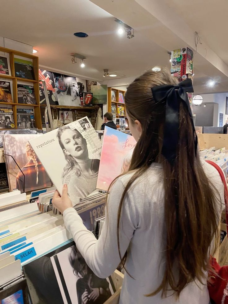 a woman looking at records in a record store