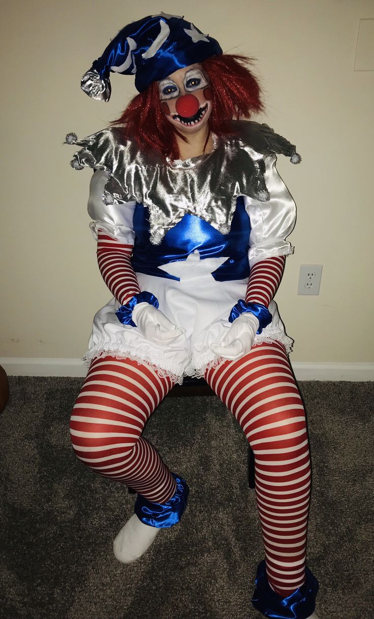 a woman dressed as a clown sitting on the floor