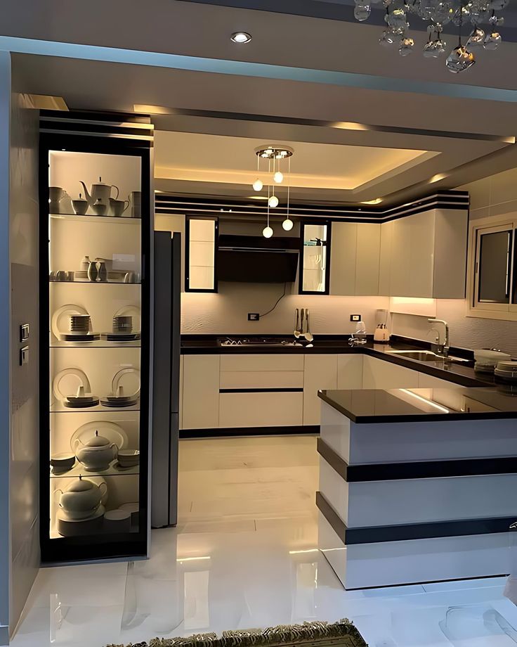 a modern kitchen with white cabinets and black counter tops, is seen from the doorway