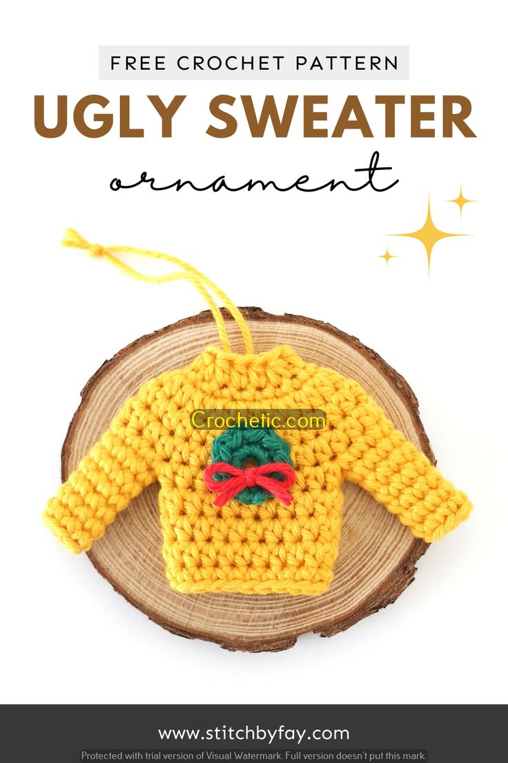 a crocheted sweater ornament on top of a piece of wood