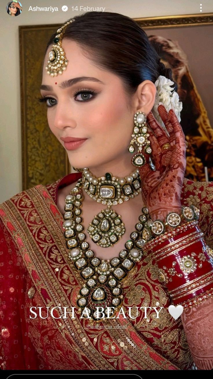 a woman wearing a red and gold bridal outfit