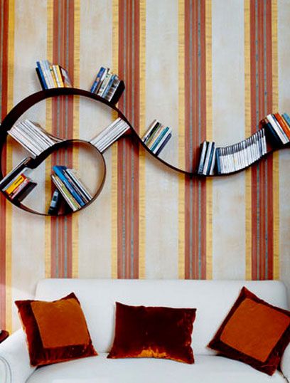 a white couch sitting in front of a wall with bookshelves on top of it