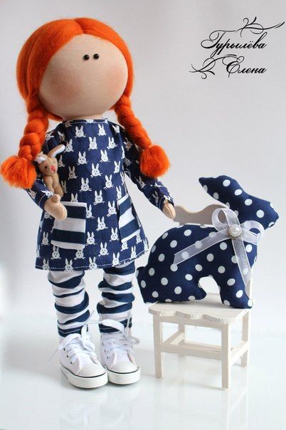 an image of a doll with red hair and polka dots on her clothes, standing next to a rocking chair